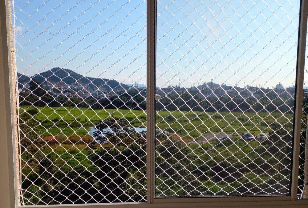 Janela com rede de proteção em area rural para proteção de gatos e cachorros.